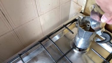 Sabah kahvesini hazırlayan küçük bir kahve makinesinin görüntüsü. Mutfaktaki ocağın üstündeki makinenin görüntüsü. Geleneksel İtalyan kahvaltısı