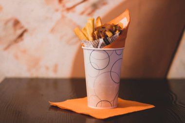 Baharatlı sos ve taze patates kızartması, ev yapımı kızarmış patates cipsi baharatlı sos ve ahşap arka planda çıtır soğan.