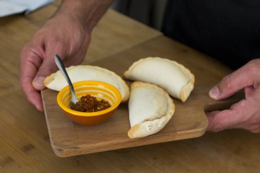 Bir aşçının erkek elleri, Lizbon 'da lüks bir fırında et, sandviç, börek, geleneksel lezzetli latin yemekleri ve vejetaryen yemekleriyle etli sandviç yapar. Sandviç yapma süreci.