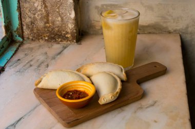 Geleneksel fırınlanmış Arjantin börekleri et dolması ve sebzelerle birlikte lezzetli hamur işleri baharatlı sos ve buzlu limon çayı, taze ve ev yapımı. Latin yemekleri ve içecekleri..