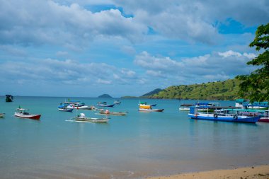 A Paradise island, tropical beach, emerald green sea with beach trees and blue sky background, Indonesia, south asia. Local people have a simple life like fishermen and sellers. Indonesia, South Asia