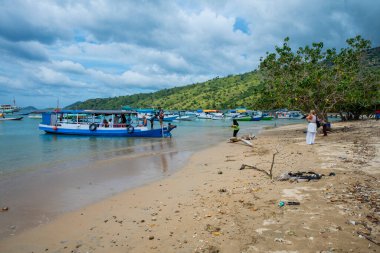 A Paradise island, tropical beach, emerald green sea with beach trees and blue sky background, Indonesia, south asia. Local people have a simple life like fishermen and sellers. Indonesia, South Asia