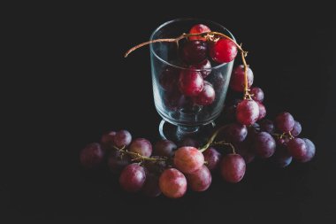 Red grapes, large bunch of fruits, fresh and tasty simple food on a dark background in a fancy minimal composition