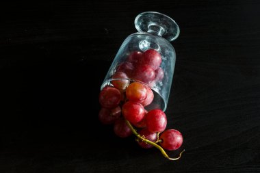 Red grapes, large bunch of fruits, fresh and tasty simple food on a dark background in a fancy minimal composition