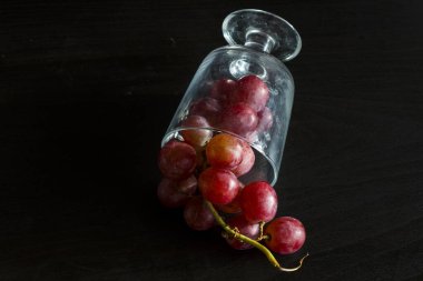 Red grapes, large bunch of fruits, fresh and tasty simple food on a dark background in a fancy minimal composition