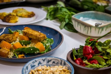 Ahşap bir masada ızgara sebze ve sağlıklı yemek tabakları. Kuşkonmaz, tofu, seitan ve Halloumi peynirli Akdeniz yemekleri. Formda kişiler için glütensiz tarifler. Yiyecek Arkaplanı