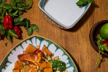 Kızarmış vejetaryen tofu ve ızgara sebze ve yoğurt soslu Yunan Halloumi ile sağlıklı bir tabak. Akdeniz yemekleri ve oryantal kuskus. Limonlar ve acı biberler dekoratif bir şekilde etrafta