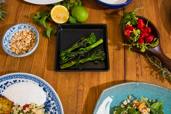 Grilled vegetables and healthy food dishes on a fancy wooden table. Mediterranean food dishes with asparagus, tofu, seitan and Halloumi cheese. Gluten free recipes for fitness persons. Food Background