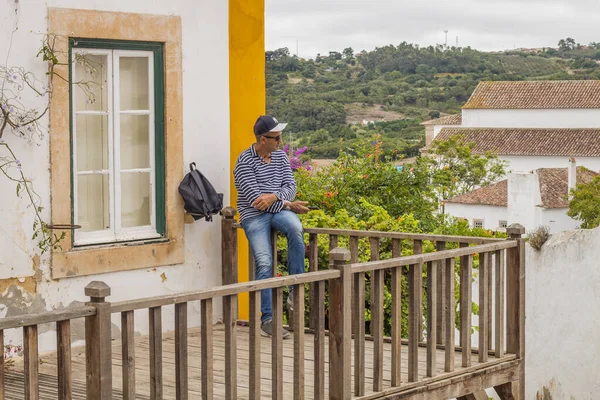 OBIDOS, PORTUGAL - 08-09-2020: Portekiz 'in orta kesiminde turistik bir yer olan ortaçağ Portekiz' in ortaçağ Portekiz kentinin hediyelik eşya dükkanları ve renkli dar sokakları. Mimarisi için ünlü hedef