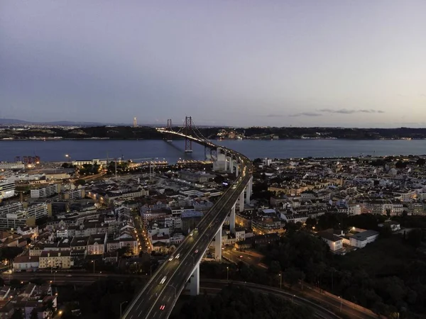 キリストと4月25日の橋の空中ビュー日没時の王の背景 夜のリスボンのスカイラインのビュー アルカンタラ リスボン ポルトガル — ストック写真