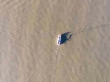 Lizbon Marina Limanı, Lizbon, Portekiz yakınlarındaki Tagus nehrinin yeşil sularında yüzen küçük turistik bir teknenin hava görüntüsü..