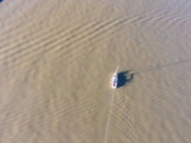 Lizbon Marina Limanı, Lizbon, Portekiz yakınlarındaki Tagus nehrinin yeşil sularında yüzen küçük turistik bir teknenin hava görüntüsü..