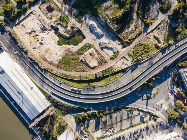 ポルトガルリスボンのタガス川沿いに建設現場がある採石場に続く都市道路の空中風景 — ストック写真