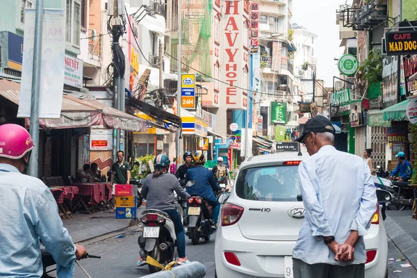Ho Chi Minh şehri, Vietnam - 7 Şubat 2021: Ho chi Minh, Vietnam 'ın merkezinde yürüyen insanlar, kalabalık caddelerde motosikletli, dükkanlı ve parklı insanlar