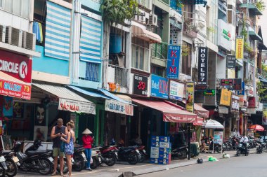 Ho Chi Minh şehri, Vietnam - 7 Şubat 2021: Ho chi Minh, Vietnam 'ın merkezinde yürüyen insanlar, kalabalık caddelerde motosikletli, dükkanlı ve parklı insanlar