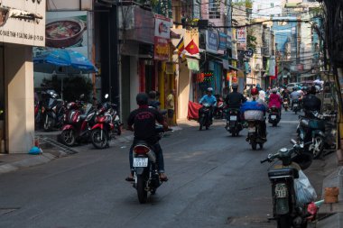 Ho Chi Minh şehri, Vietnam - 7 Şubat 2021: Ho chi Minh, Vietnam 'ın merkezinde yürüyen insanlar, kalabalık caddelerde motosikletli, dükkanlı ve parklı insanlar