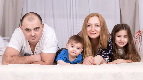 Retrato de la familia acostada en la cama — Foto de Stock