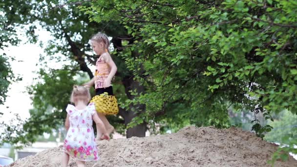 Kinderen springen in de zandbak — Stockvideo