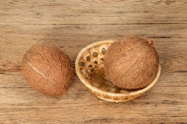 Coco en cesta en la mesa — Foto de Stock