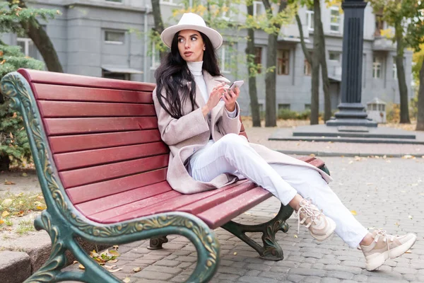 Mulher com telefone no banco — Fotografia de Stock