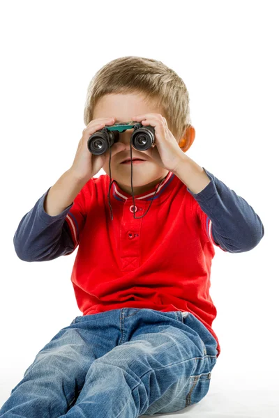 Ragazzo seduto e guardando attraverso il binocolo — Foto Stock