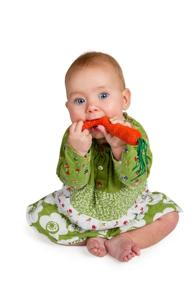 Baby eats carrots knitted — Stock Photo, Image