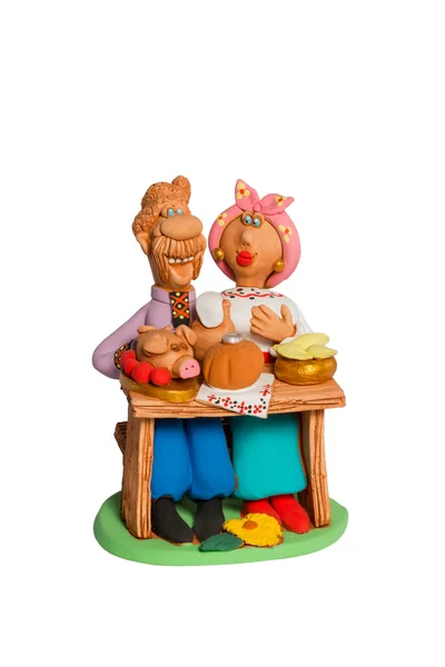 Statuette of a husband and wife at the table with food — Stock Photo, Image