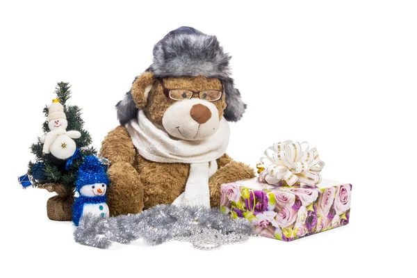 Teddy bear in glasses scarf hat near Christmas tree — Stock Photo, Image