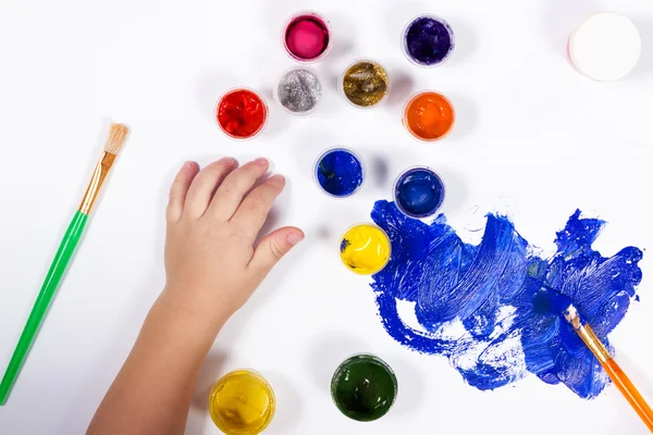 Niños manos pintadas con un pincel sobre papel — Foto de Stock