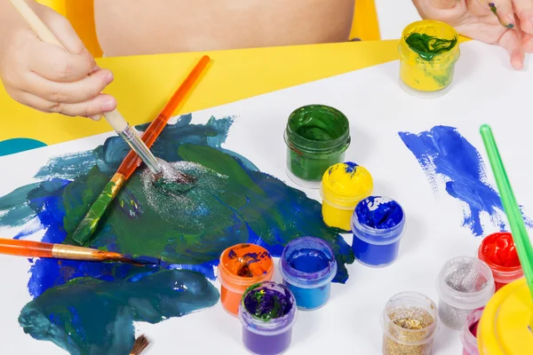 Niño dibuja pintura en una hoja —  Fotos de Stock