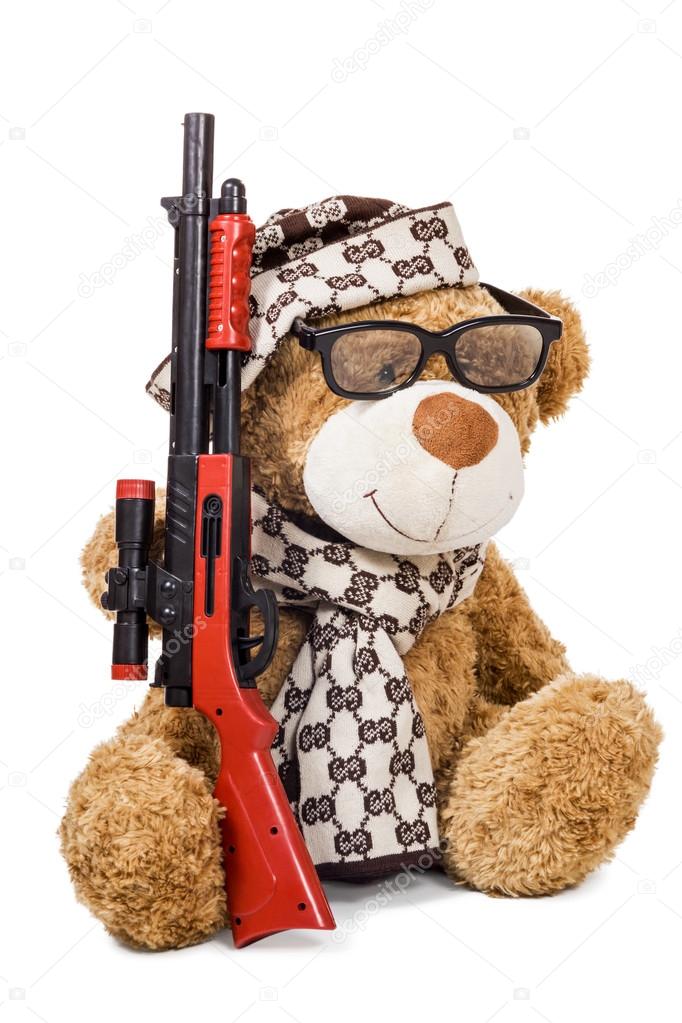 Teddy bear in cap and scarf with rifle