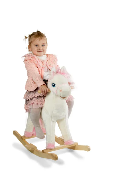 Bella bambina cavalcando il suo cavallo giocattolo — Foto Stock
