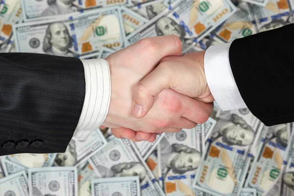 Handshake of businessmen on banknotes background — Stock Photo, Image