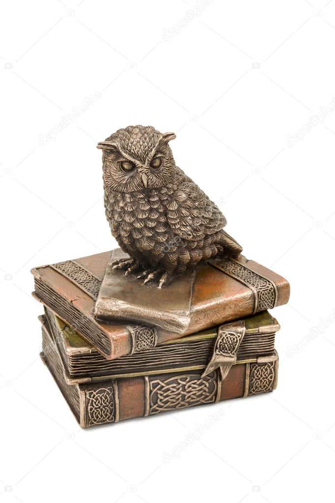 Statuette owl sitting on books