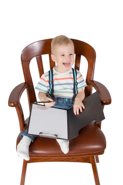 Criança rindo sentada em uma cadeira — Fotografia de Stock