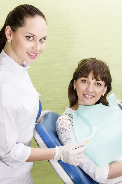 Dentysta oferuje pacjent szczoteczka do zębów — Zdjęcie stockowe