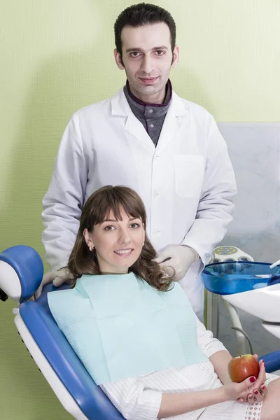 Retrato de joven dentista feliz y paciente en clínica — Foto de Stock