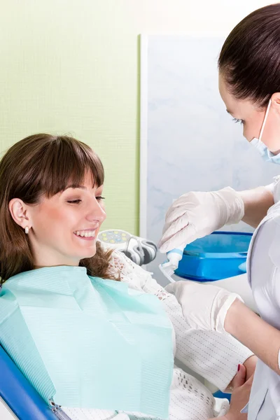 Dentista enseñando a un paciente a cepillarse los dientes — Foto de Stock