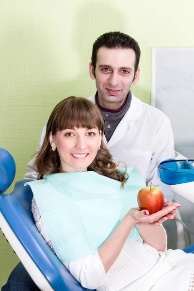 Dentist man and patient woman with apple — Stock Photo, Image