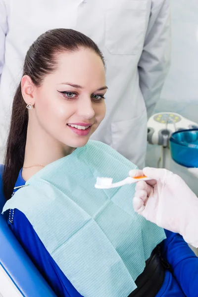 Dentista paciente y cepillo de dientes — Foto de Stock
