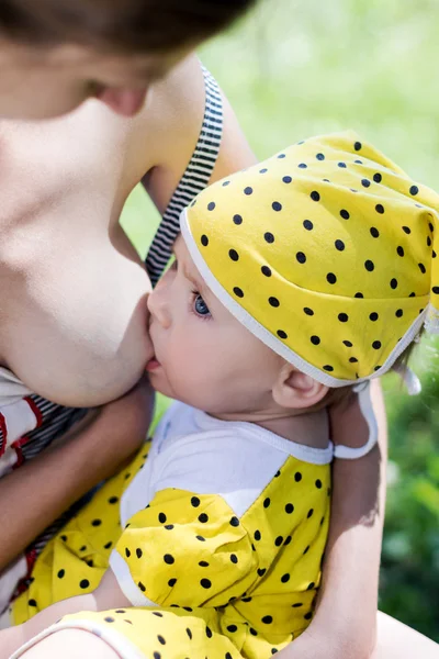 Mother breastfeeding a baby in nature — Stock Photo, Image