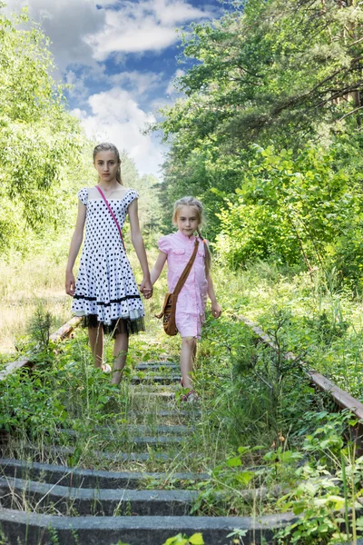 Two sisters walking along railway — Stock Photo, Image