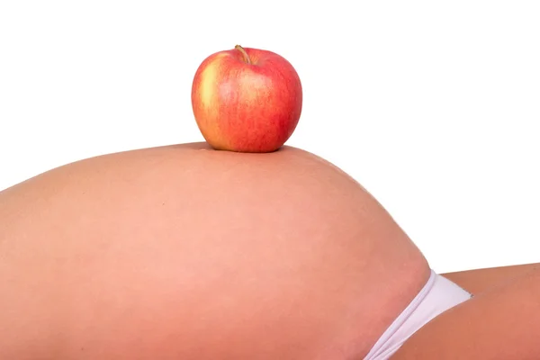 Zwangere buik met rode appel — Stockfoto