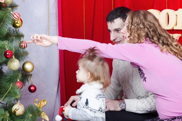 Family decorating a Christmas tree — Stock Photo, Image