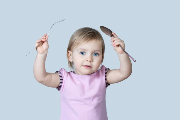 Pequeño bebé con una cuchara y tenedor — Foto de Stock