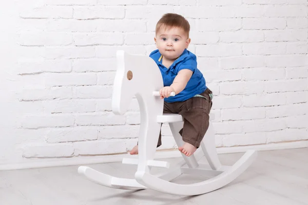 Engraçado bebê sentado no cavalo de brinquedo — Fotografia de Stock
