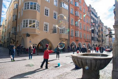 Eski Innsbruck kasabasının merkez caddesinde balon sanatları yapan genç bir sokak sanatçısı. 15 Ekim 2016 'da Avusturya' nın Innsbruck kentinde çekildi.