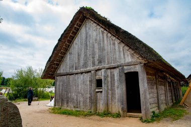 Reconstructed Viking thatched house on the basis of archaeological finds in Viking Haithabu village. Taken in Busdorf, Germany on July 15, 2016 clipart