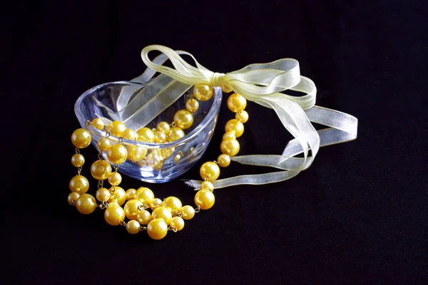 Golden pearls in love shape glass — Stock Photo, Image