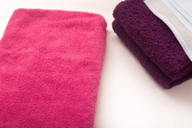 Beyaz arka planda gül ve menekşe havlular, banyo havlularında hijyen maskeleri. Yüksek kalite fotoğraf